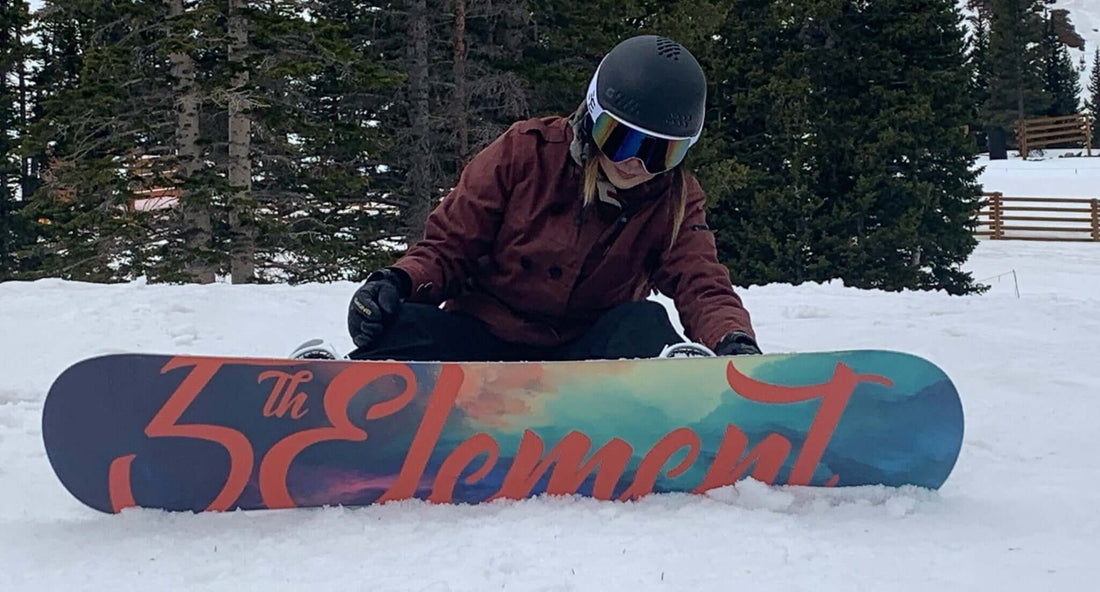 Woman strapping into snowboard