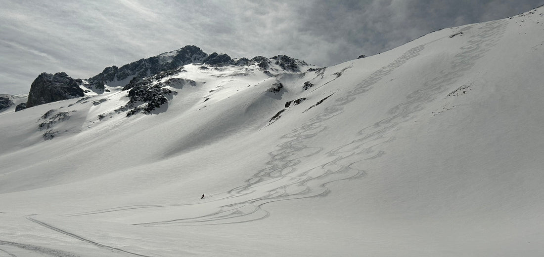 Snowy mountains with skier carving turns