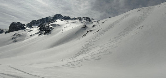 Snowy mountains with skier carving turns
