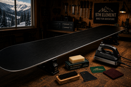 Snowboard on a workbench with waxing iron, wax, scraper and brush